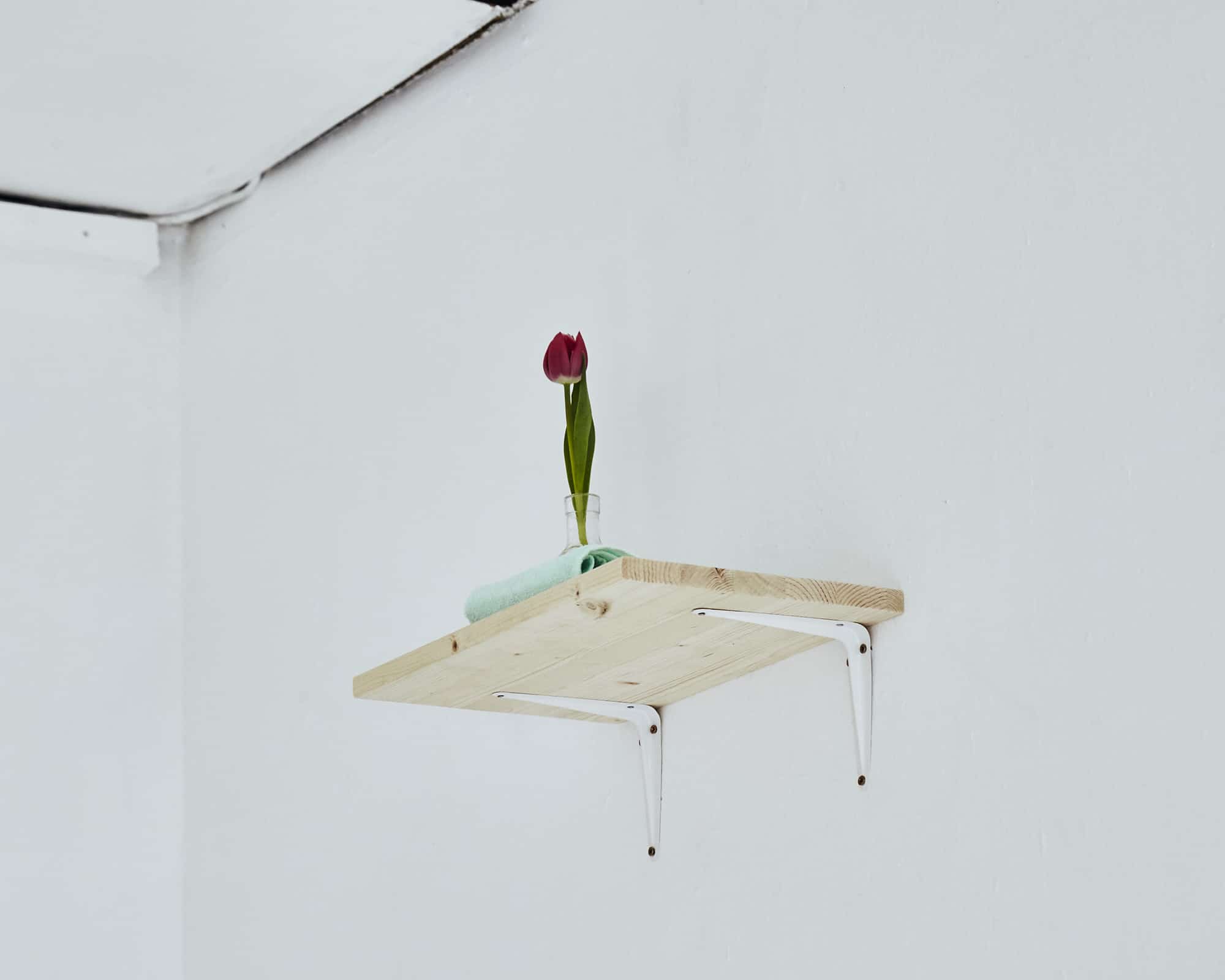 Belfast (PS2), 2015 Wooden shelf with metal brackets, fresh flower in a bottle with water, borrowed map of Luzern, light green towel, meteorite (Taza) and tamarind. Photo: Simon Mills